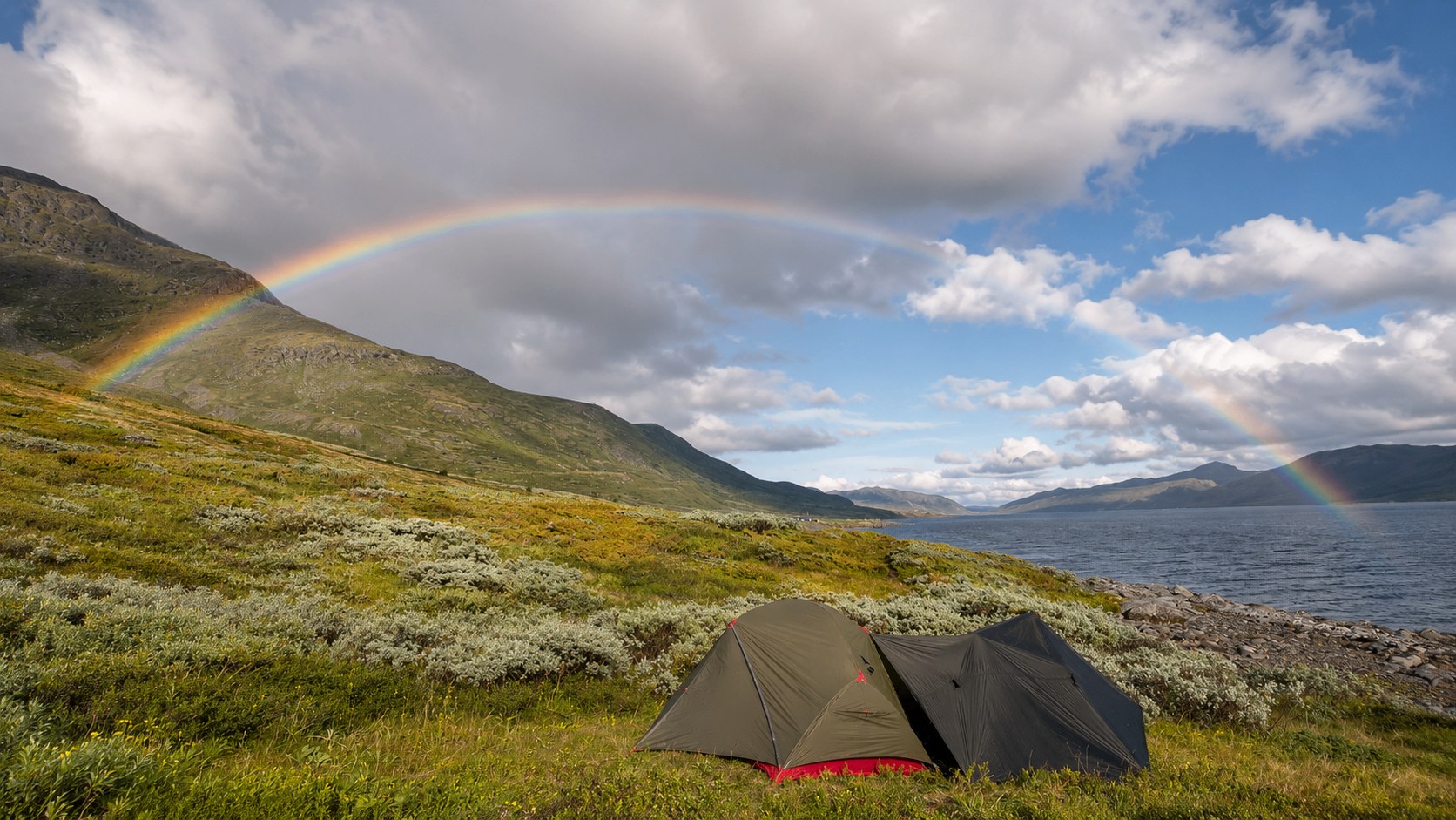 Tent met regenboog boven een meer tijdens een trektocht in Noorwegen