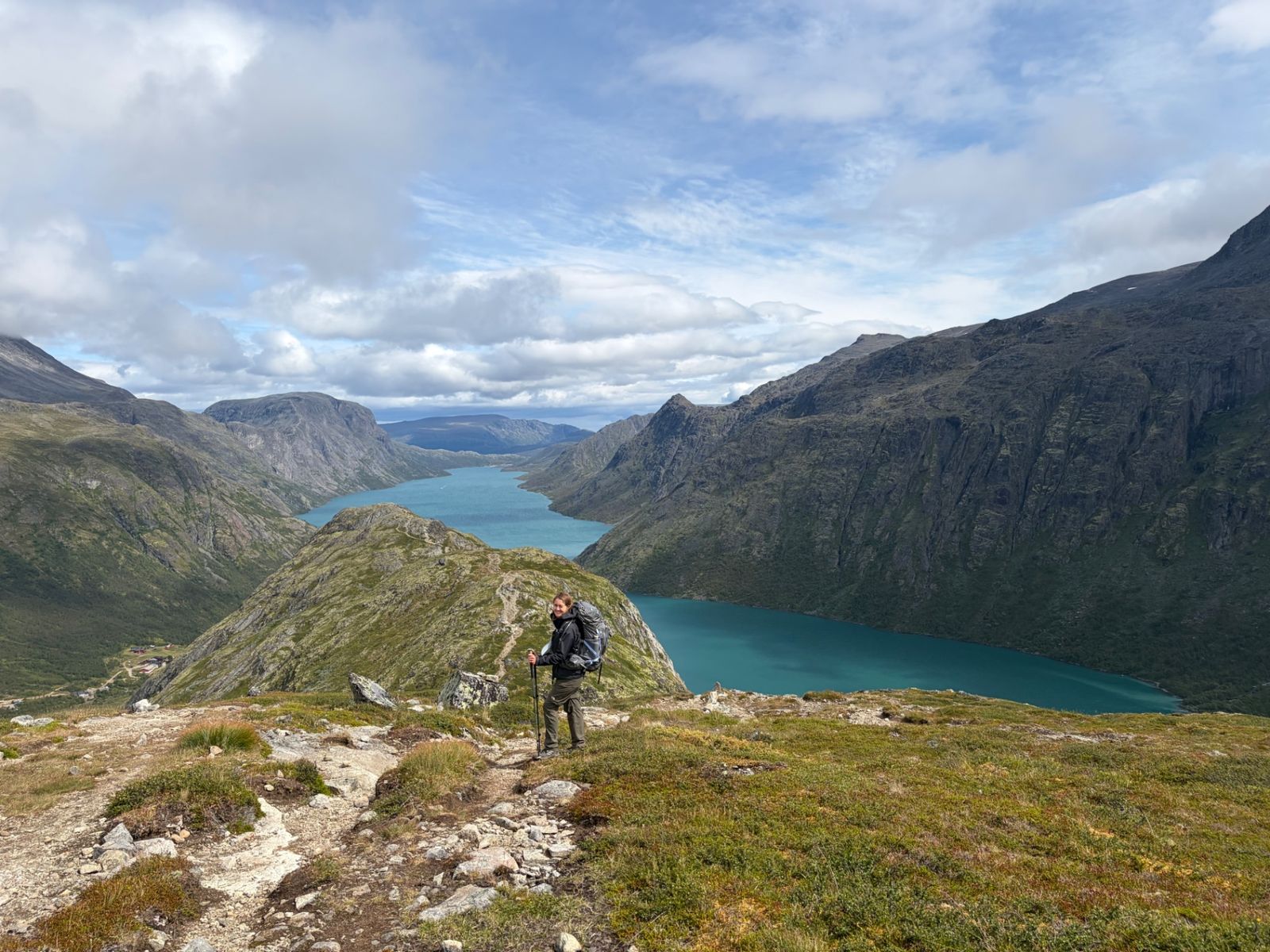 Hiker with a backpack above Lake Gjende in Jotunheimen, Norway