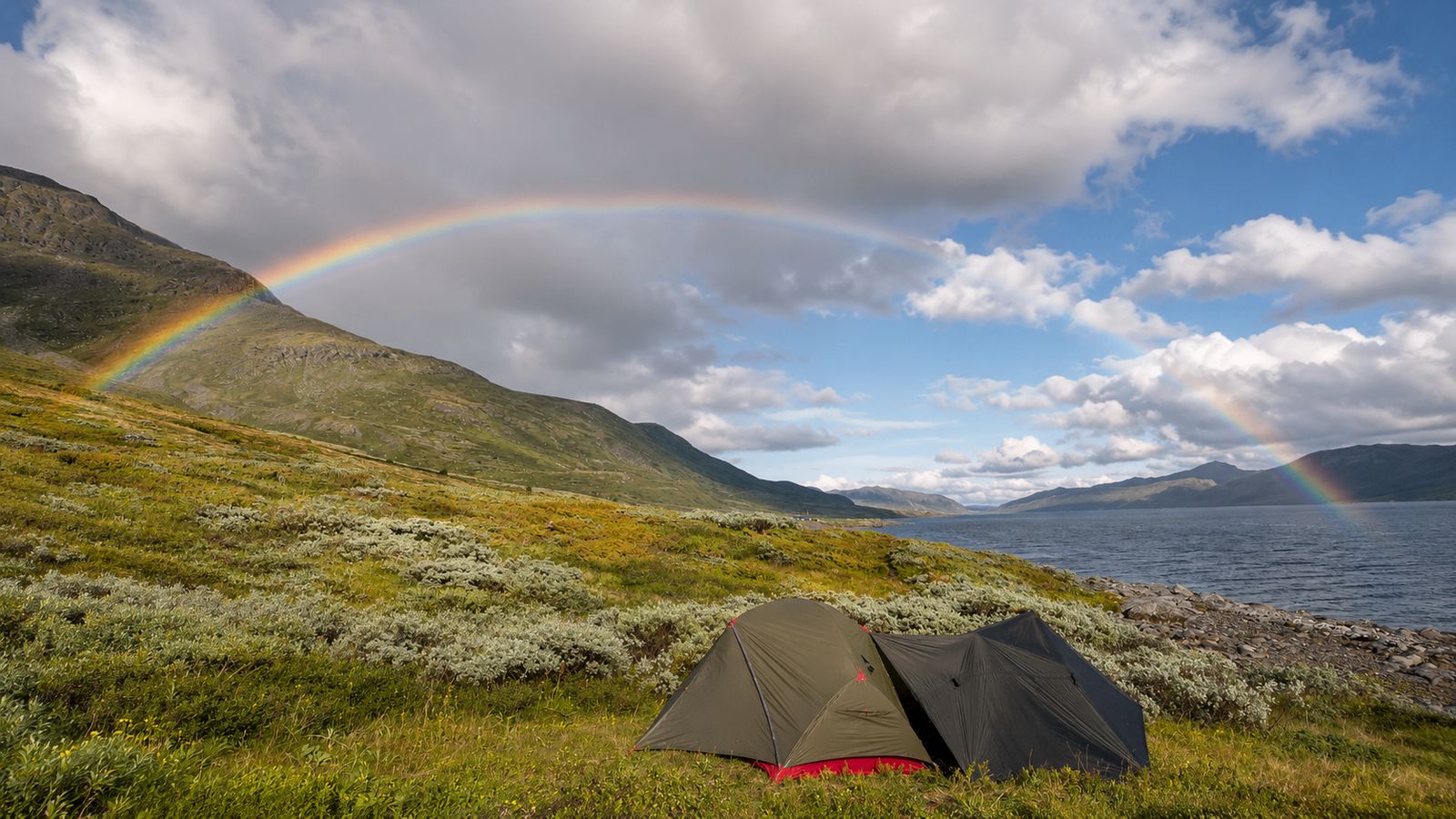 MSR tent with tarp by a Norwegian lake with a rainbow over the mountains